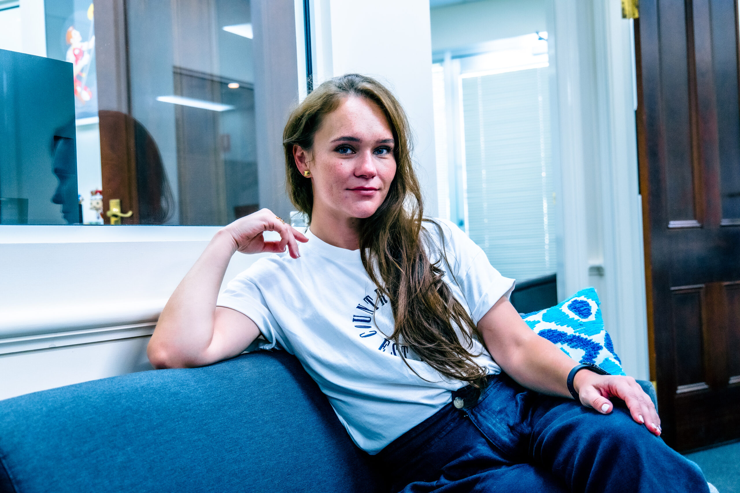 Portrait of Olga Burtseva seated in the boardroom facing the camera behind an open HP laptop.